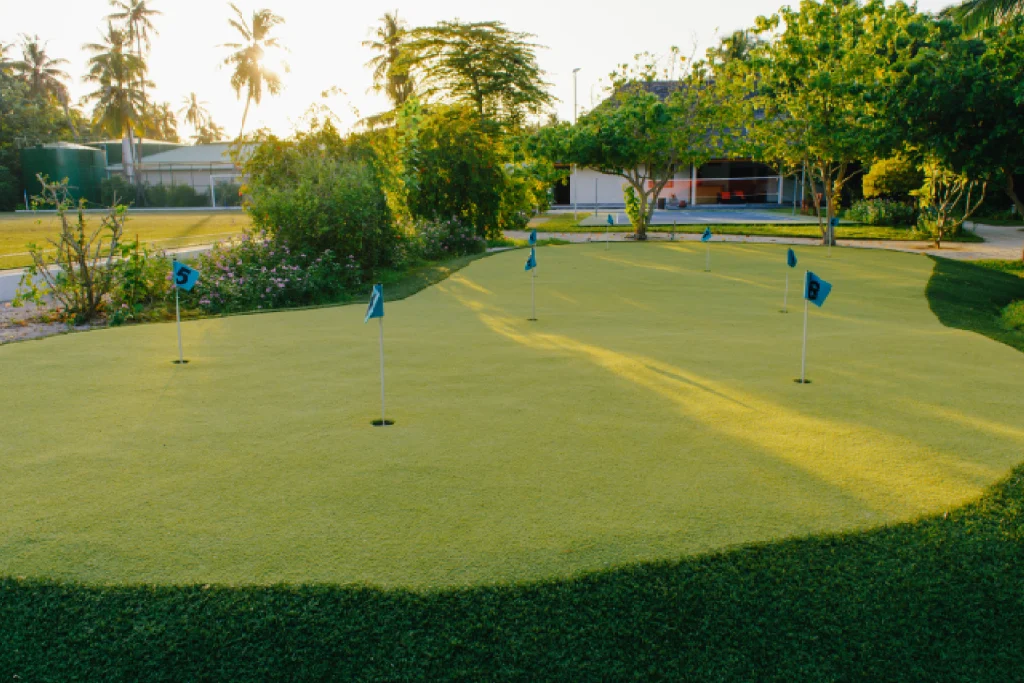 An aerial view of a compact 9-hole golf course nestled within a small piece of land