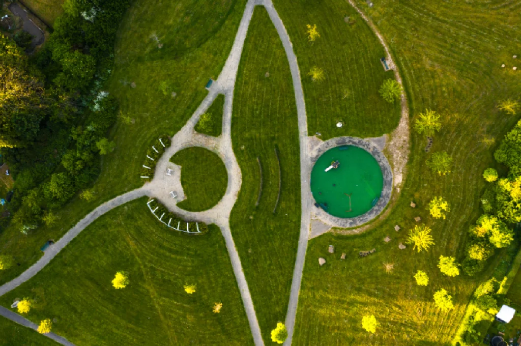 A schematic overhead view of a complex miniature golf hole showing intricate slopes and water features.