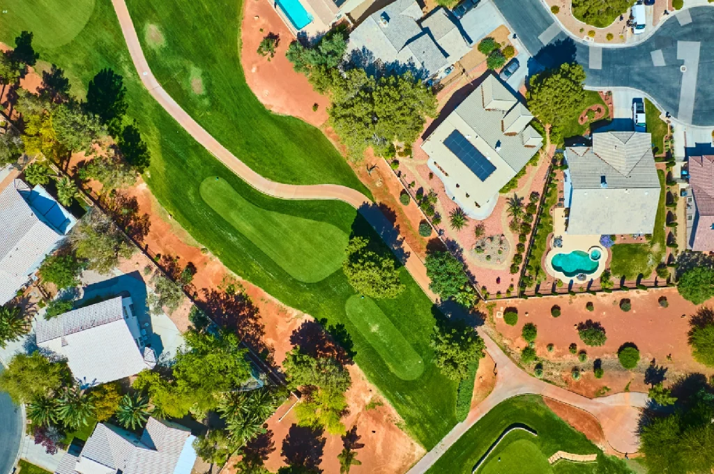 An aerial view of a compact executive golf course nestled within an urban mixed-use development