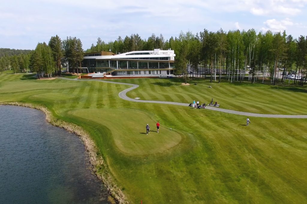 An aerial view of a modern golf course featuring flexible tee boxes and naturalized waste areas.