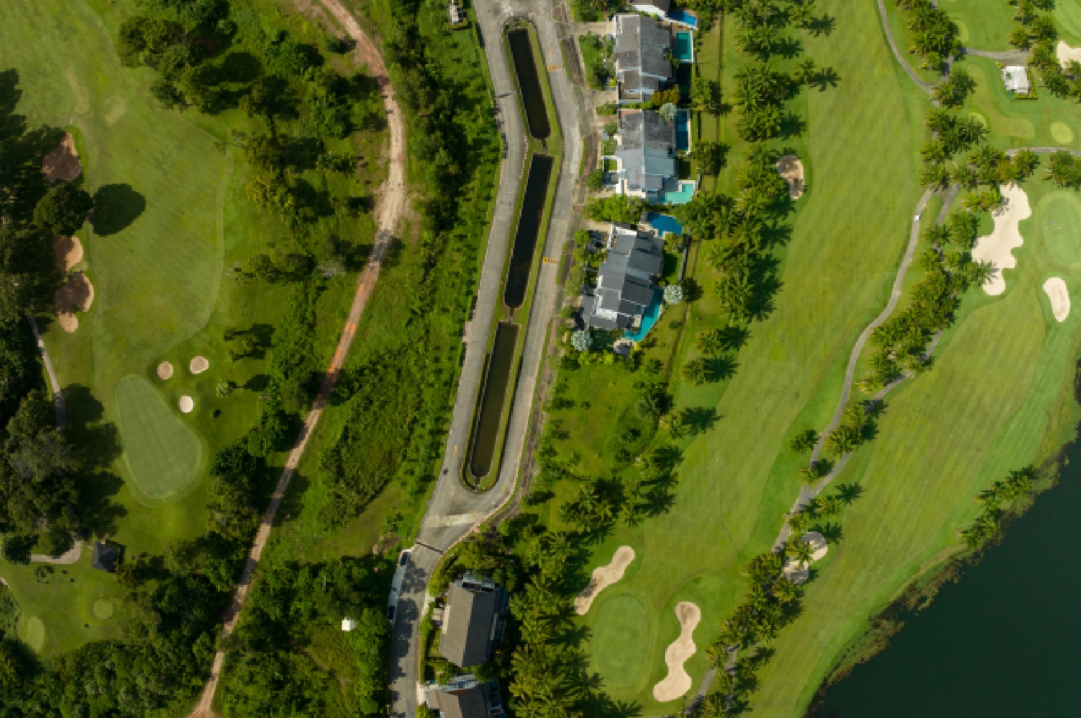 An aerial view of a compact executive golf course nestled within an urban mixed-use development