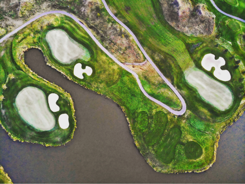 A golf course routing map illustrating the preservation of natural wetland boundaries and existing forest clusters integrated into the course layout.