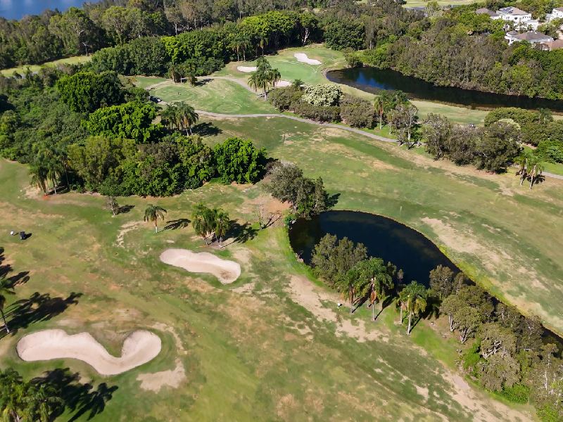 A wide view of a modern championship course winding naturally through rolling hills and dramatic elevation shifts