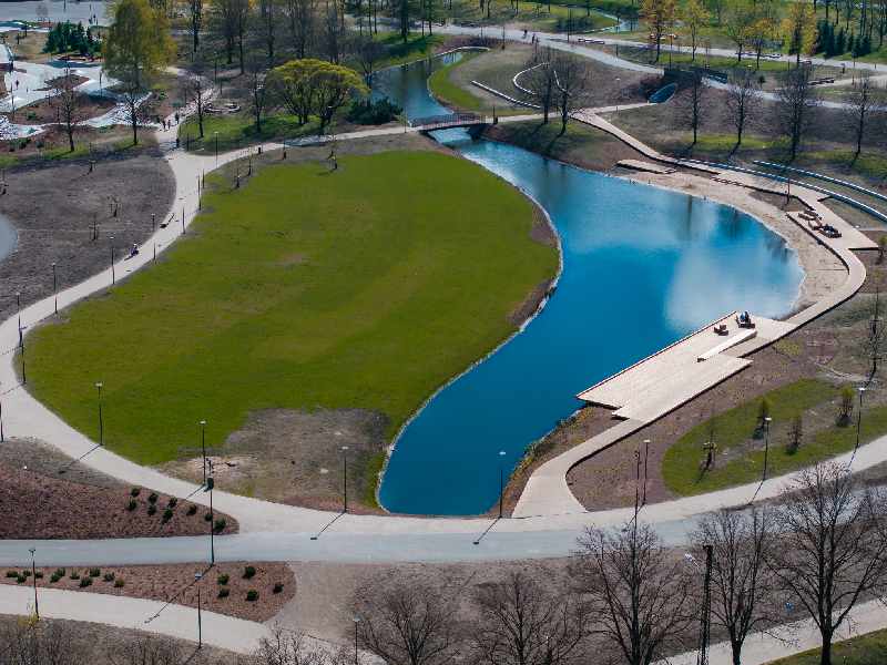 A wide view of an elegant championship course featuring an expansive, polymer-lined water harvesting lake and native landscaping.