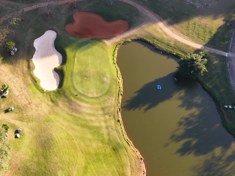 Bio-retention stormwater harvesting lake engineered by a top golf architect in India for an eco-friendly resort layout.