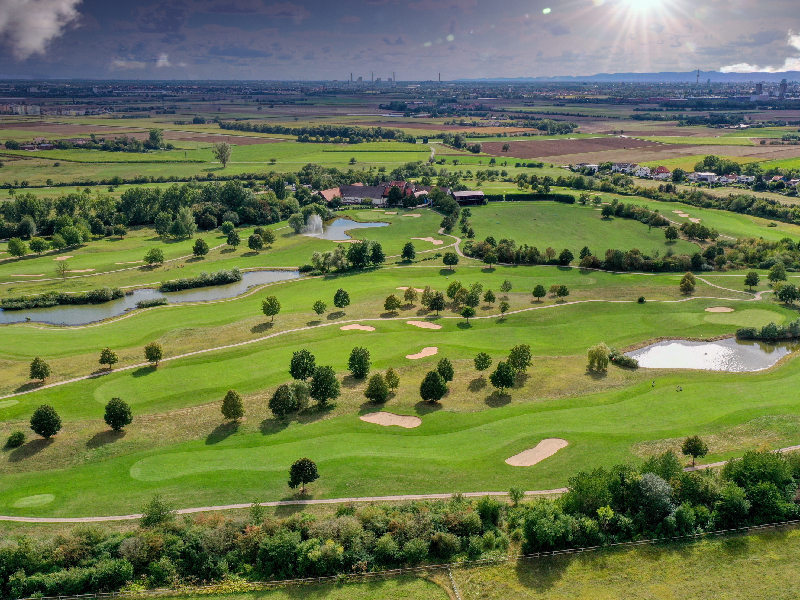 High-angle panoramic view of a modern championship course showcasing sustainable golf design and master planning excellence.